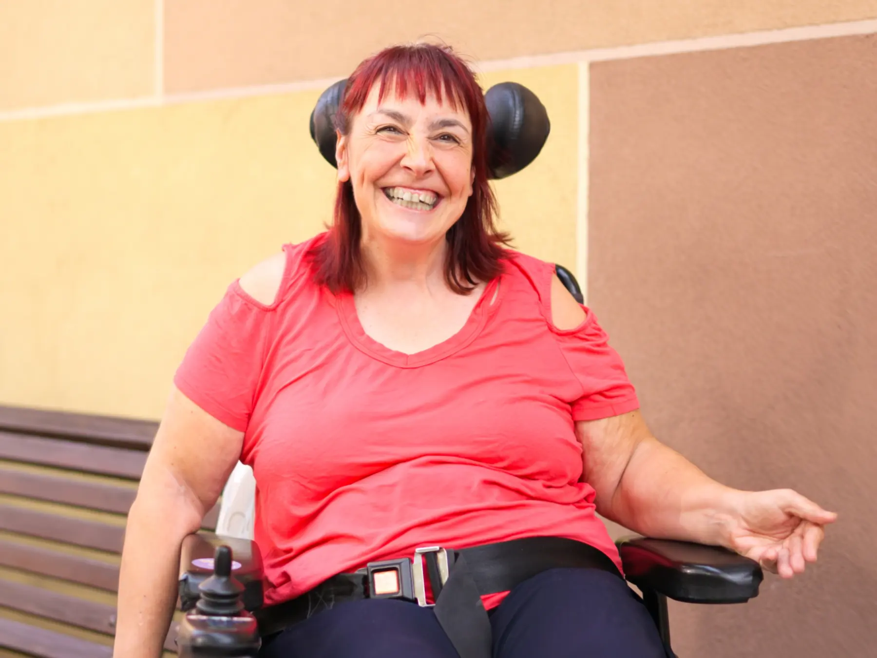 A smiling wheelchair user enjoying time outdoors