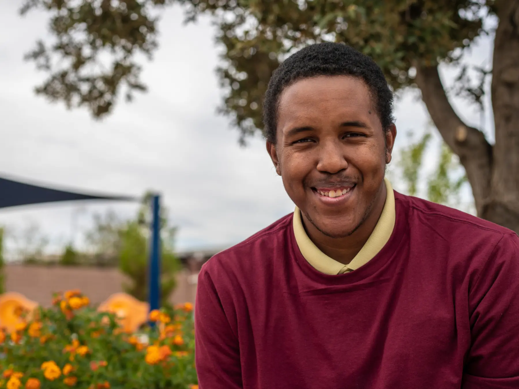 A welcoming community member smiling outdoors