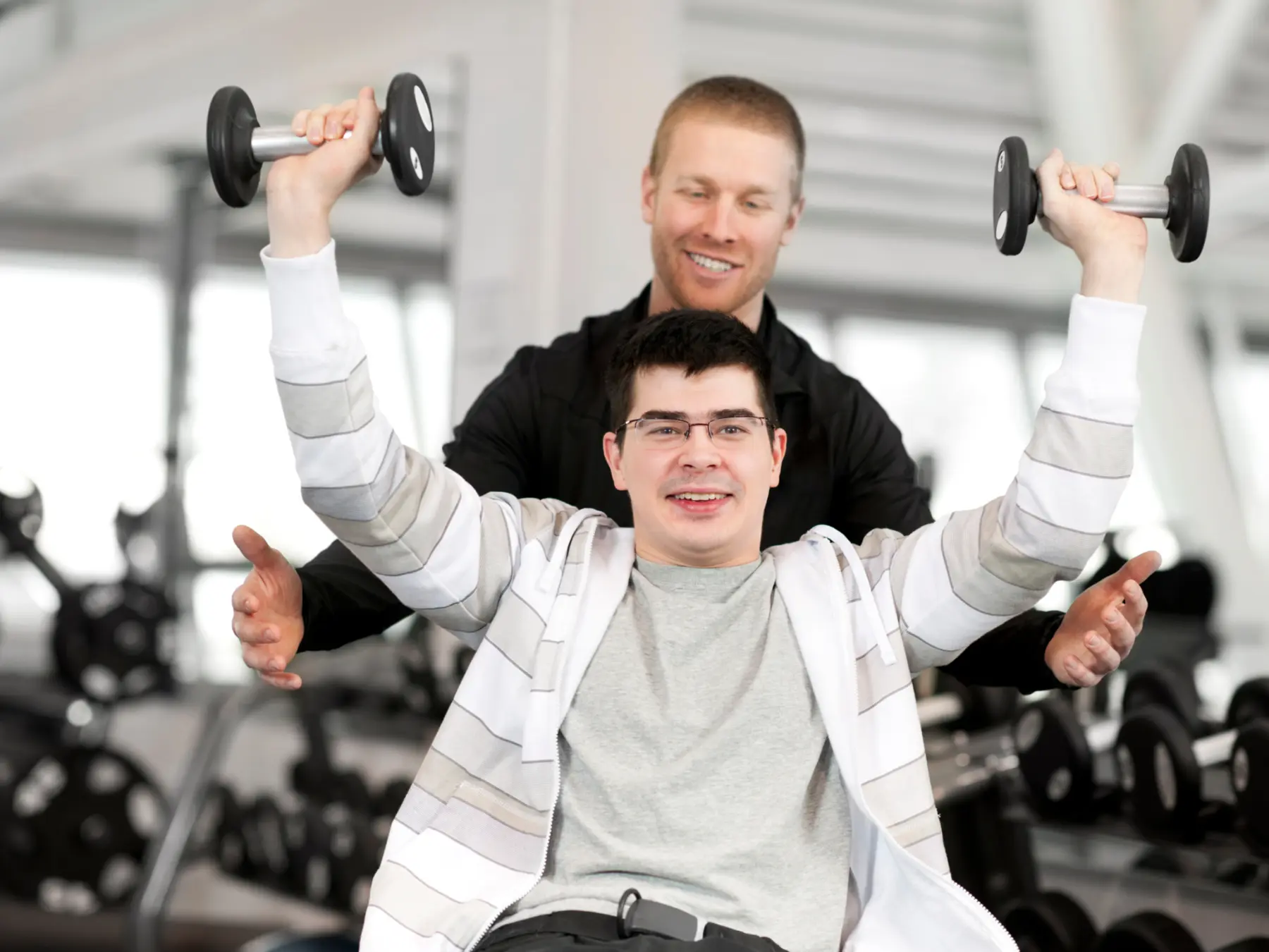 An adult building strength with support from a fitness professional