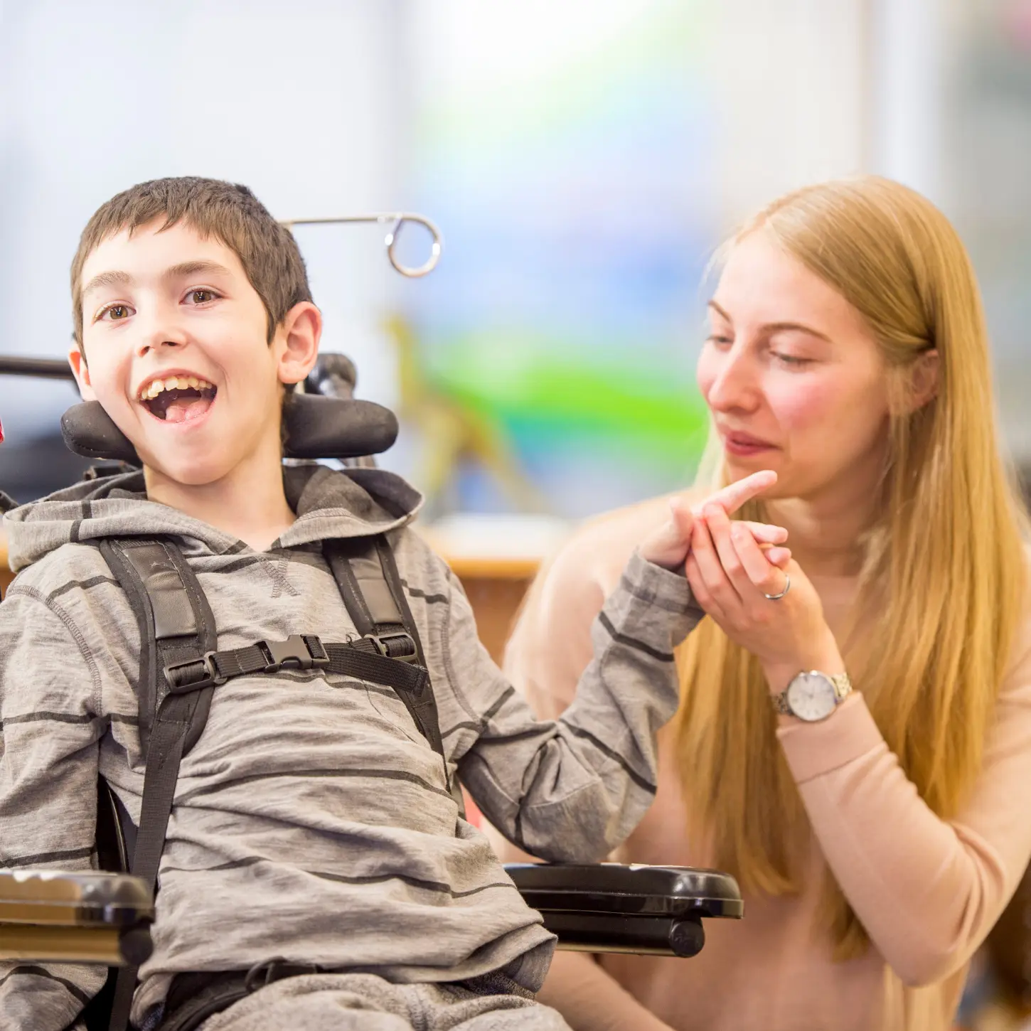 A support professional listening and communicating with a young person who uses a wheelchair